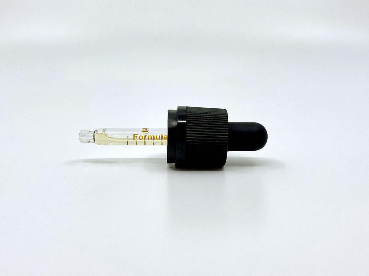 Pipete ar CBD eļļu olīveļļā uz balta fona